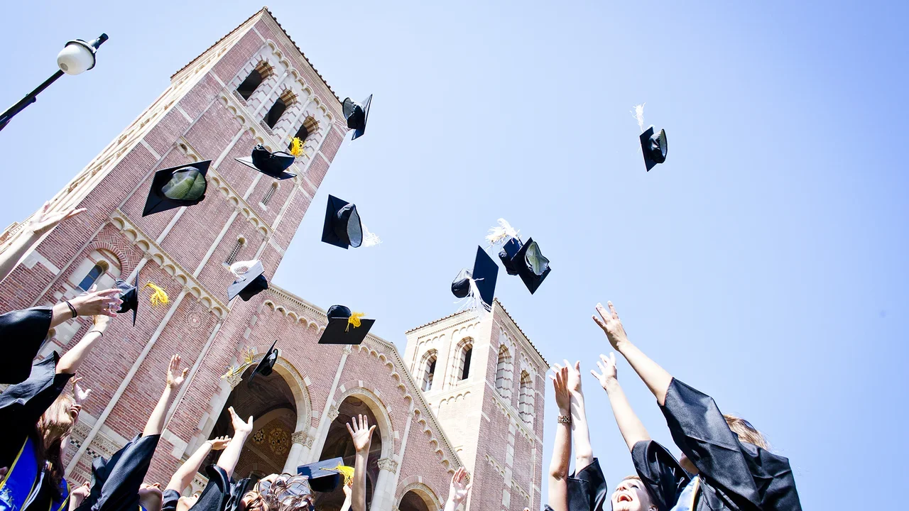 Students throwing their caps in the air in front of Royce Hall