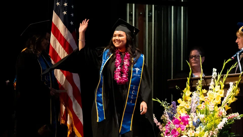 A student walking across the commencement stage