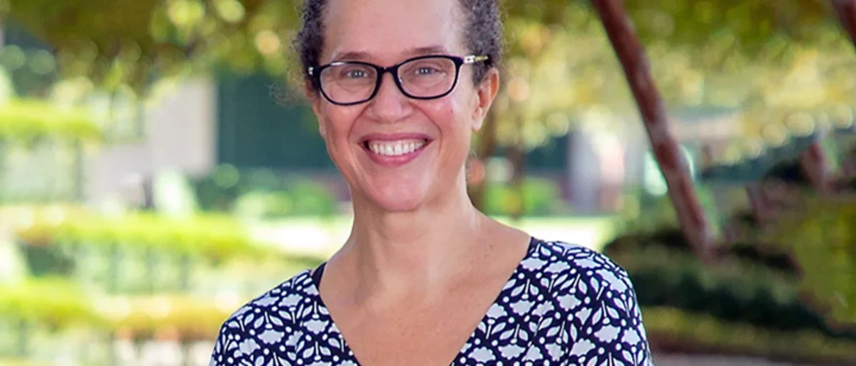 A woman with glasses wearing a purple shirt