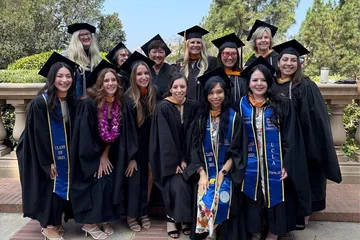 A group of UCLA Nursing master's students and faculty posing in their regalia
