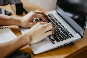 A person hands sitting on a laptop keyboard