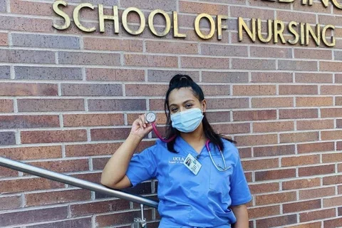 Alumni student standing in front of the Factor Building