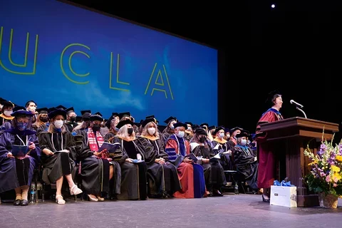 UCLA Nursing faculty on stage at the 2022 Commencement Ceremony. Dean Lin Zhan is at the podium
