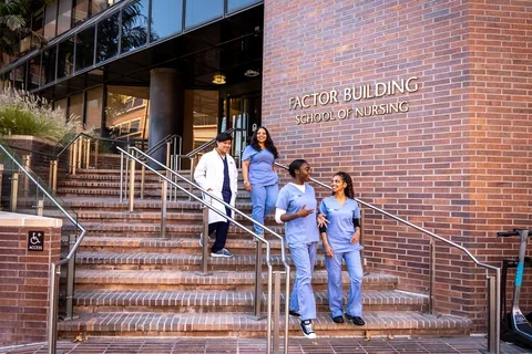 Nursing students walking down the steps of the Factor Building