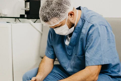 A male nurse with his head down