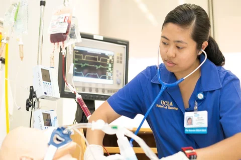 A nursing student working with a Simulation Lab mannequin