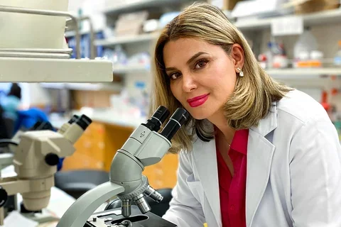 A researcher standing over a microscope