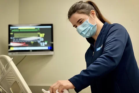 Nursing staff member Sasha Karlin cleaning a simulation mannequin. 