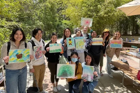 A group of students posing for a photo while holding the art they created during Sunshine & Color