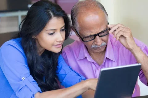 A man and woman looking at a tablet together