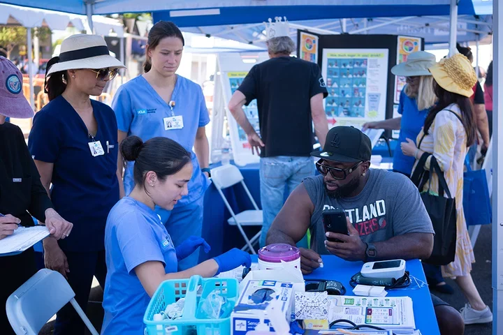 A UCLA Nursing student providing a health screening