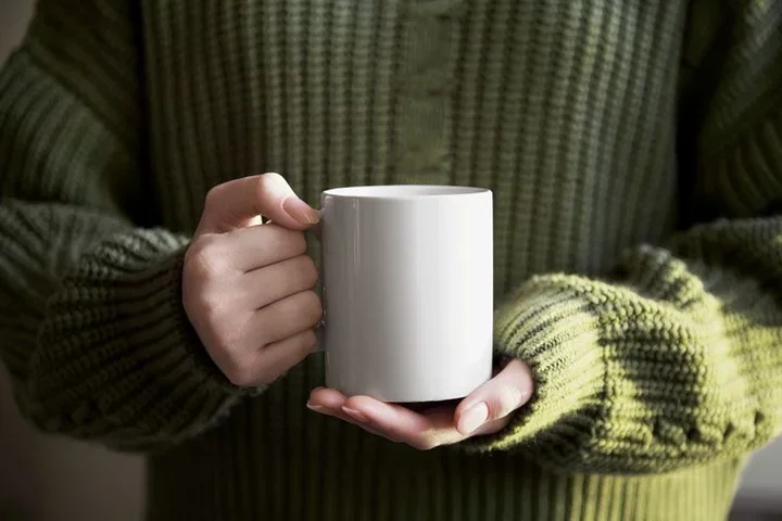 A person holding a cup of coffee