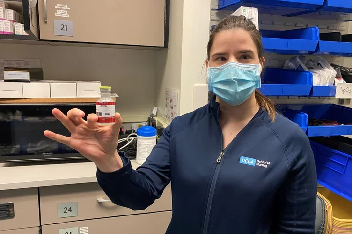 Sasha Karlin holding a vial of imitation medicine used in the simulation lab