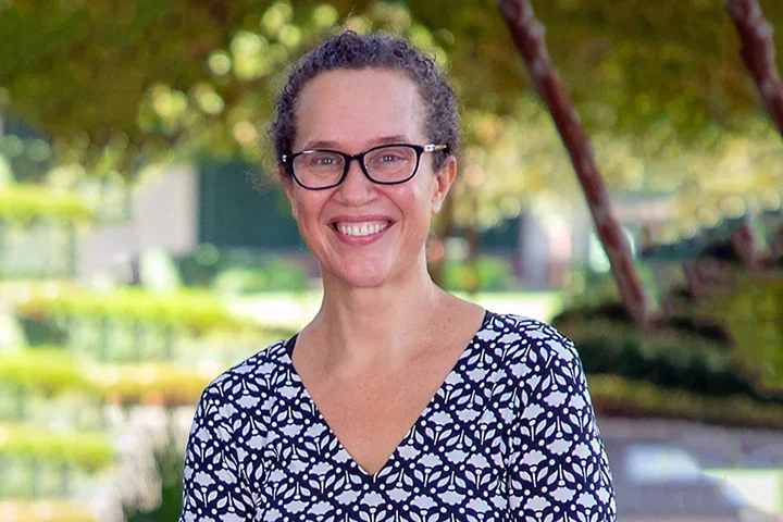 A woman with glasses wearing a purple shirt