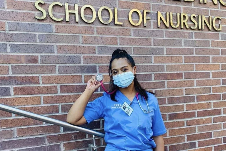 Alumni student standing in front of the Factor Building