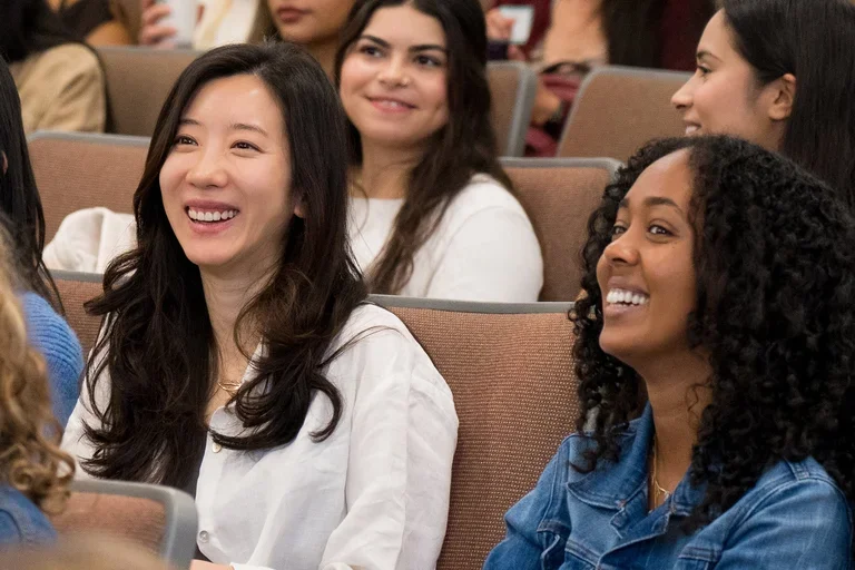 People sitting in an auditorium smiling