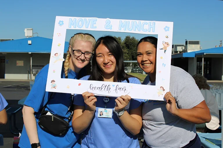 Megan Nim, Kristi Westphaln, and Joanna Paulson in scrubs at the Move & Munch event.