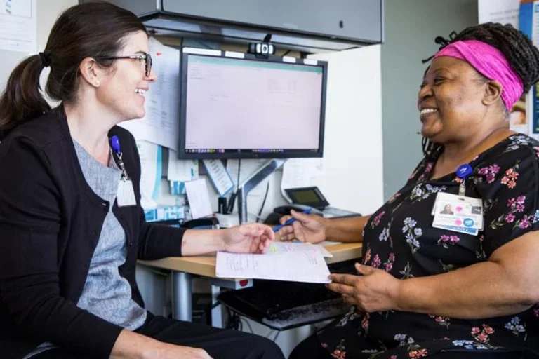 Two nurses speaking with one antother