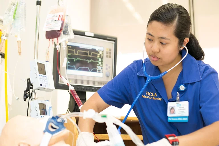 A nursing student working with a Simulation Lab mannequin