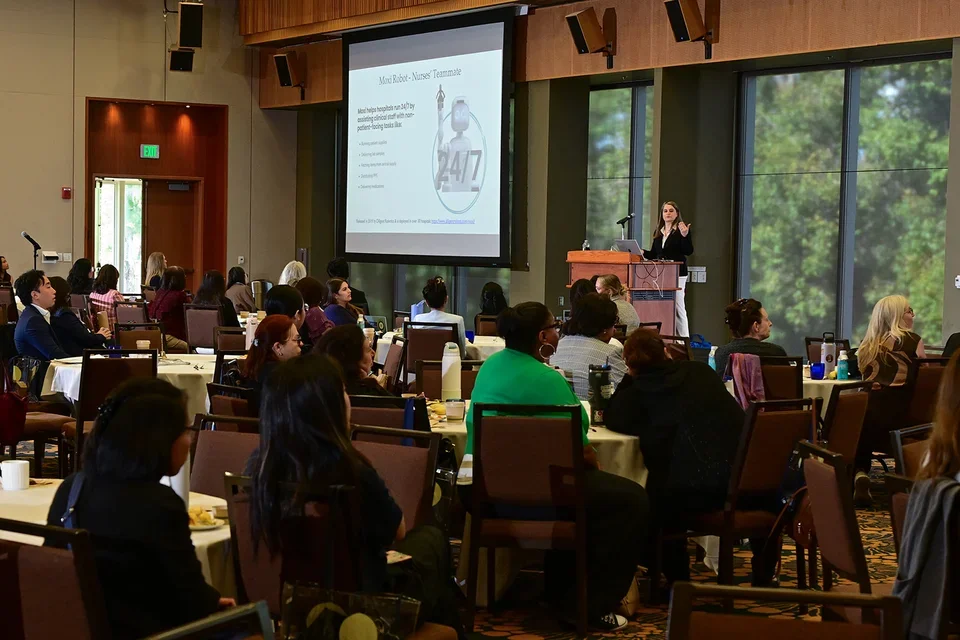 A crowd of conference attendees seated in the ballroom listening to Dr. Olga Kagan's keynote presentation.