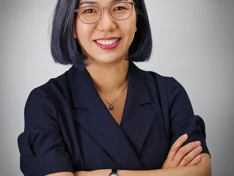 Dr. Sarah Ko headshot, wearing glasses and dark collared shirt.