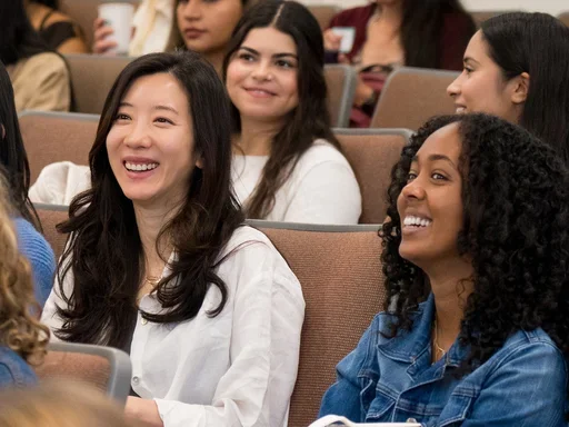 People sitting in an auditorium smiling