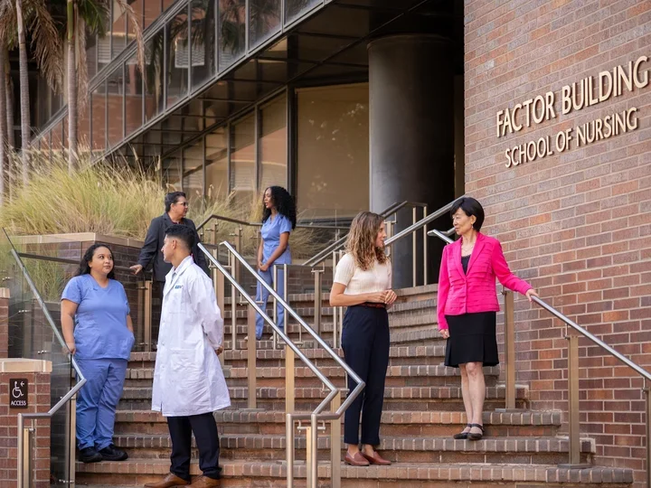 UCLA Nursing Dean Lin Zhan speaking with students in front of the School of Nursing.