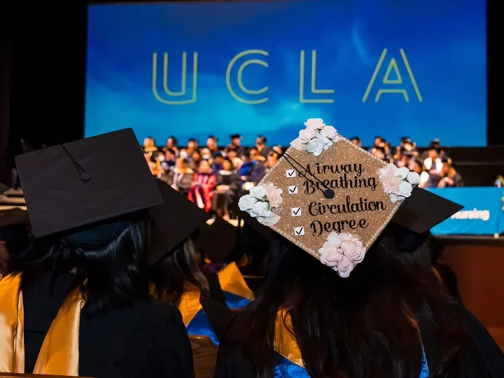 A nursing student's graduation cap at commencement with a check box design and the words airway, breathing, circulation, degree. 