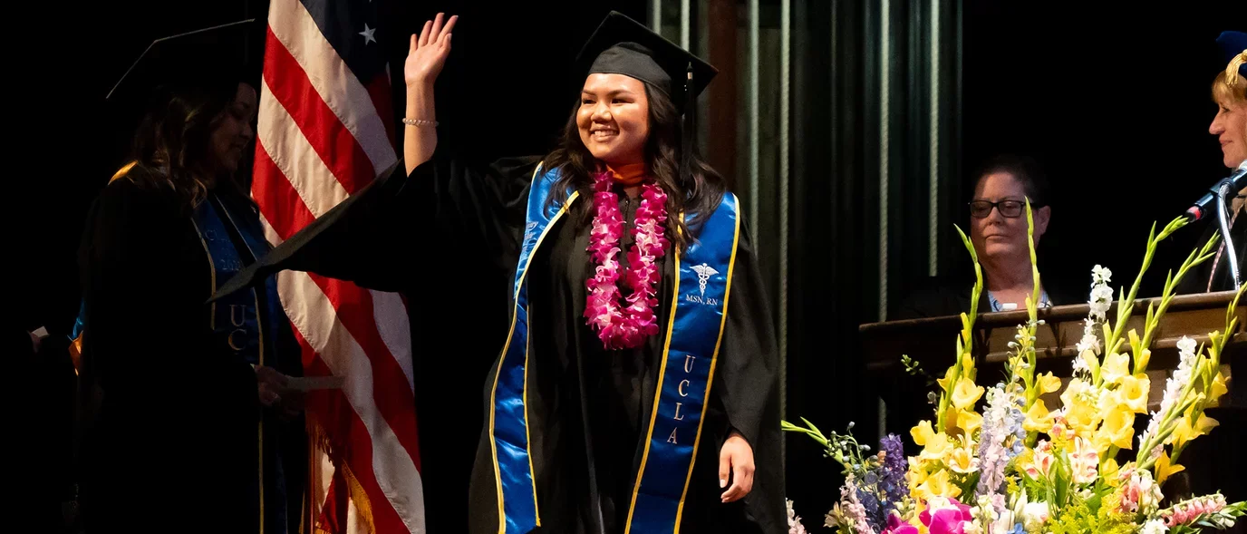 A student walking across the commencement stage