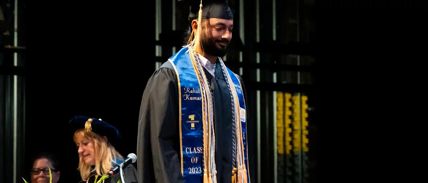 A student walking across the commencement stage