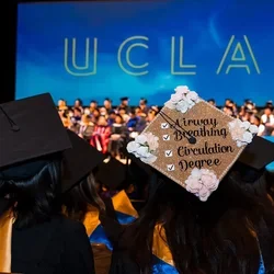 A nursing student's graduation cap at commencement with a check box design and the words airway, breathing, circulation, degree. 