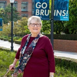 Linda Gorman on the UCLA campus with a Go Bruin sign in the background.