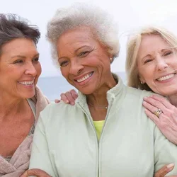 Three woman huddled together and smiling
