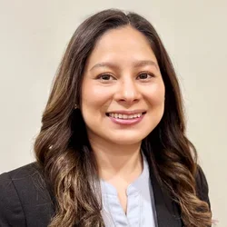 Nursing alumna Jeanette Ruiz wearing a black jacket and blue shirt. 