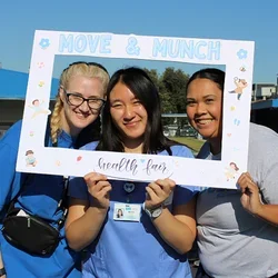 Megan Nim, Kristi Westphaln, and Joanna Paulson in scrubs at the Move & Munch event.