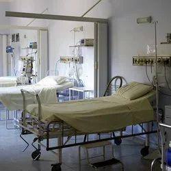 A hospital room with multiple empty beds