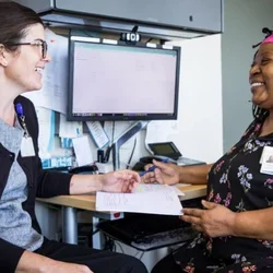 Two nurses speaking with one antother