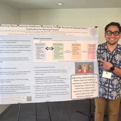 Paolo Roca standing with a research poster he presented at a recent conference.