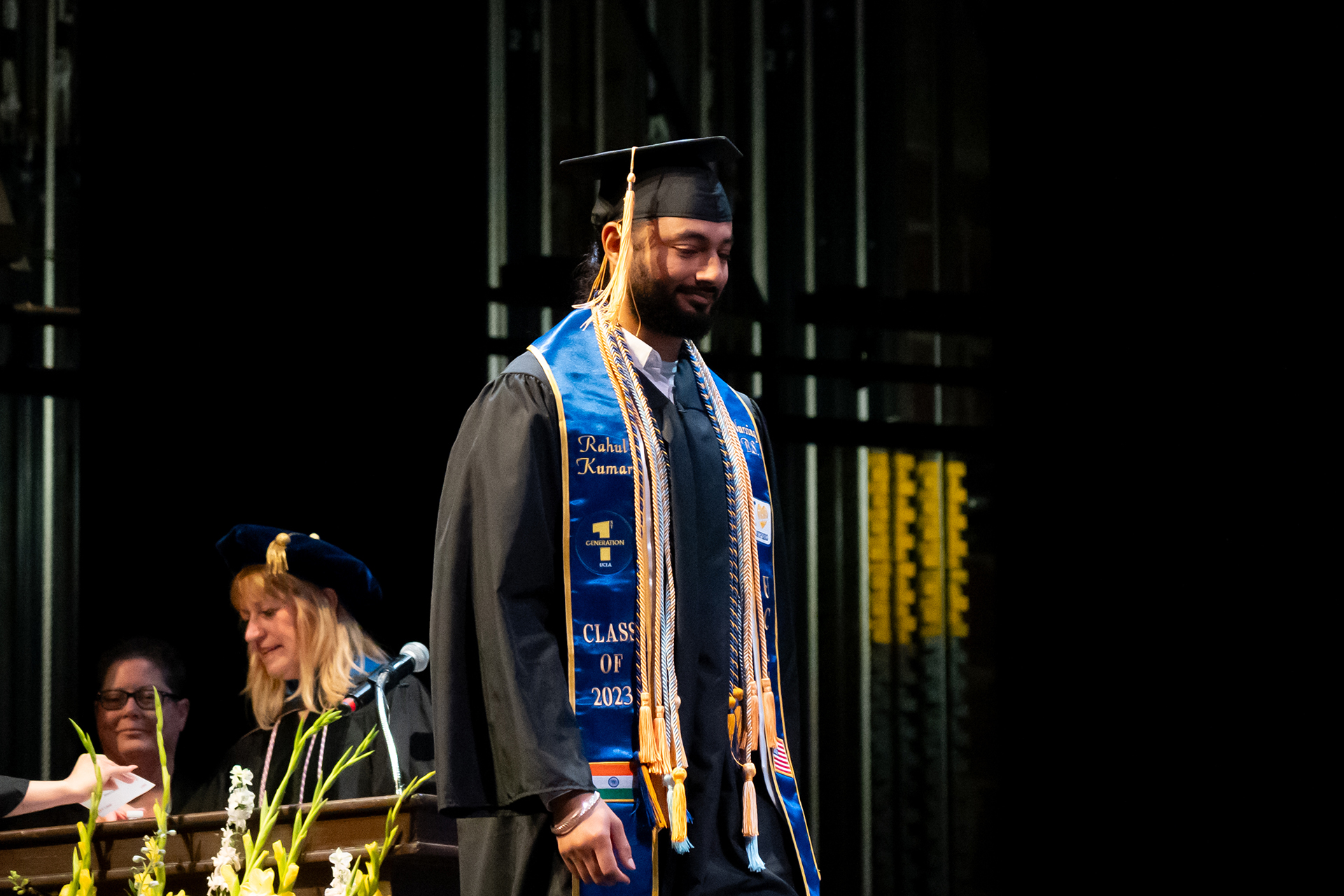 A student walking across the commencement stage