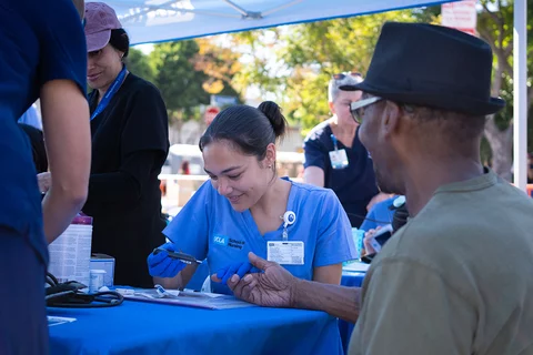 A UCLA nrusing student providing a health screening