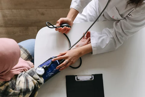 A stock image of a doctor checking blood pressure of a patient