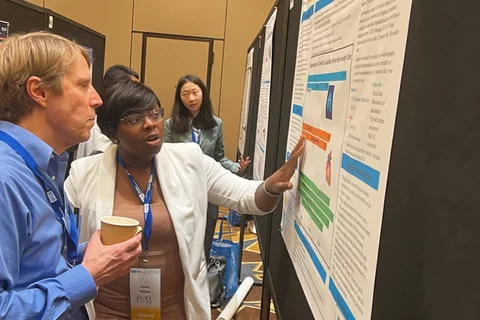 Korie Bigbee presenting her research to a conference attendee