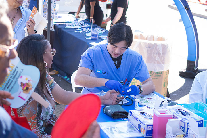 A UCLA Nursing student providing a health screening