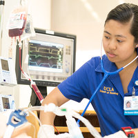 A nursing student working with a Simulation Lab mannequin